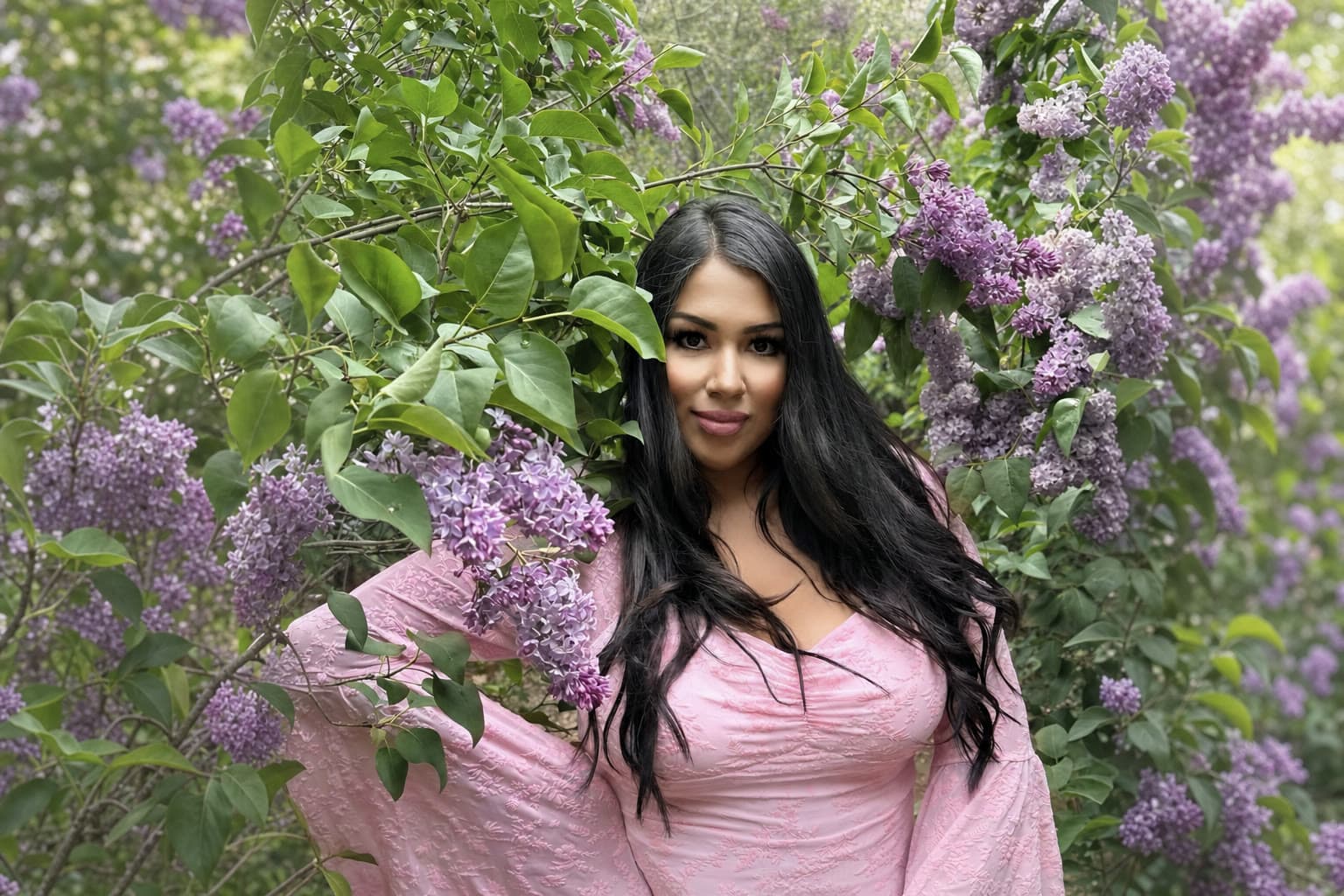 Gina, the founder of Pixxie Picnics, among blooming lilac in soft natural daylight