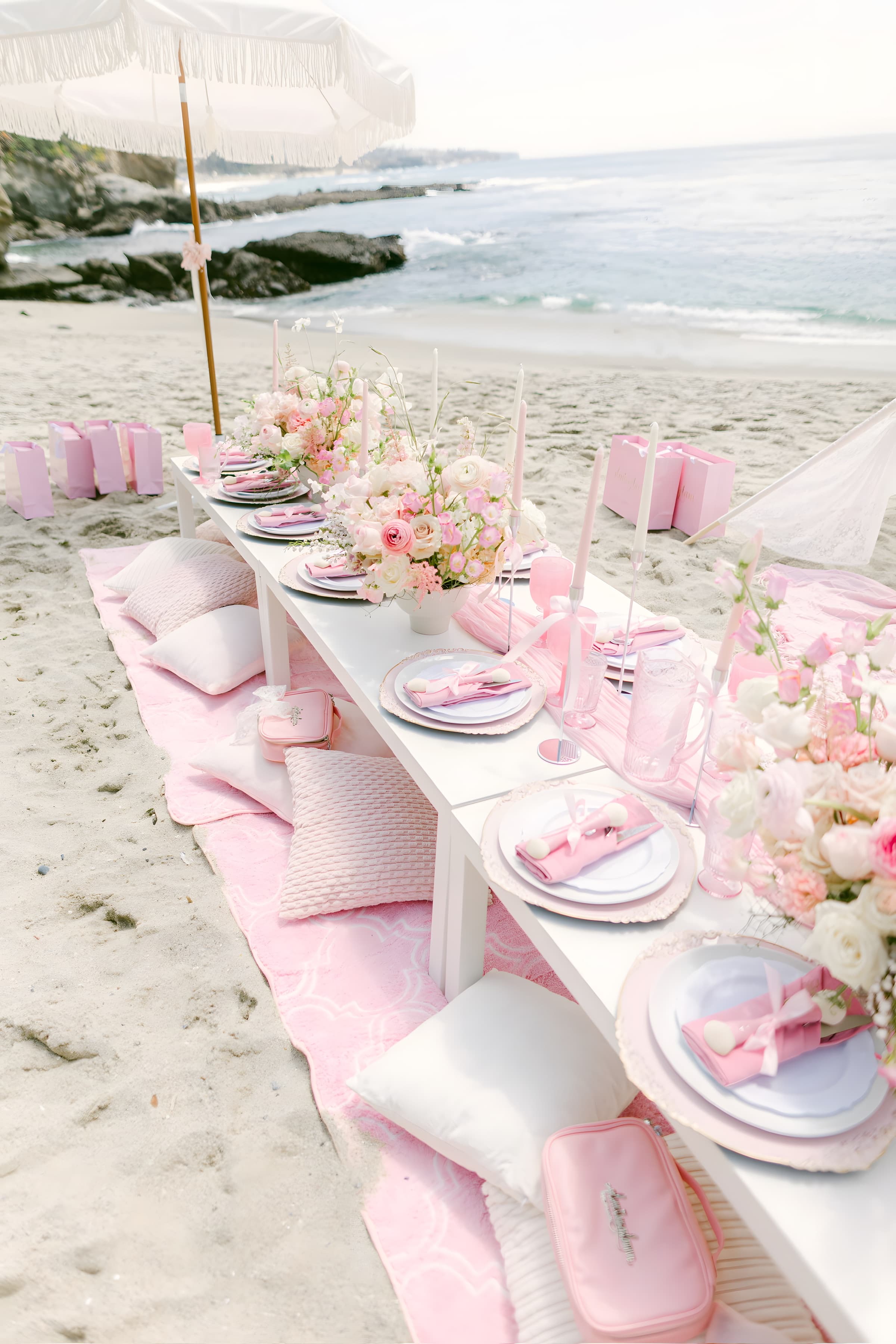 A macro of a blush garden-rose and ranunculus centerpiece over white china and a pink napkin